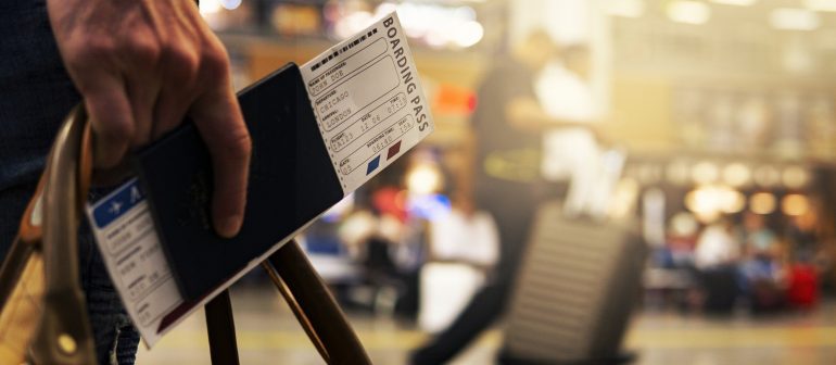 Reisender mit Bordkarte und Tasche am Flughafen