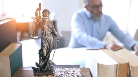 Justitia als Statue auf Bücherstapel